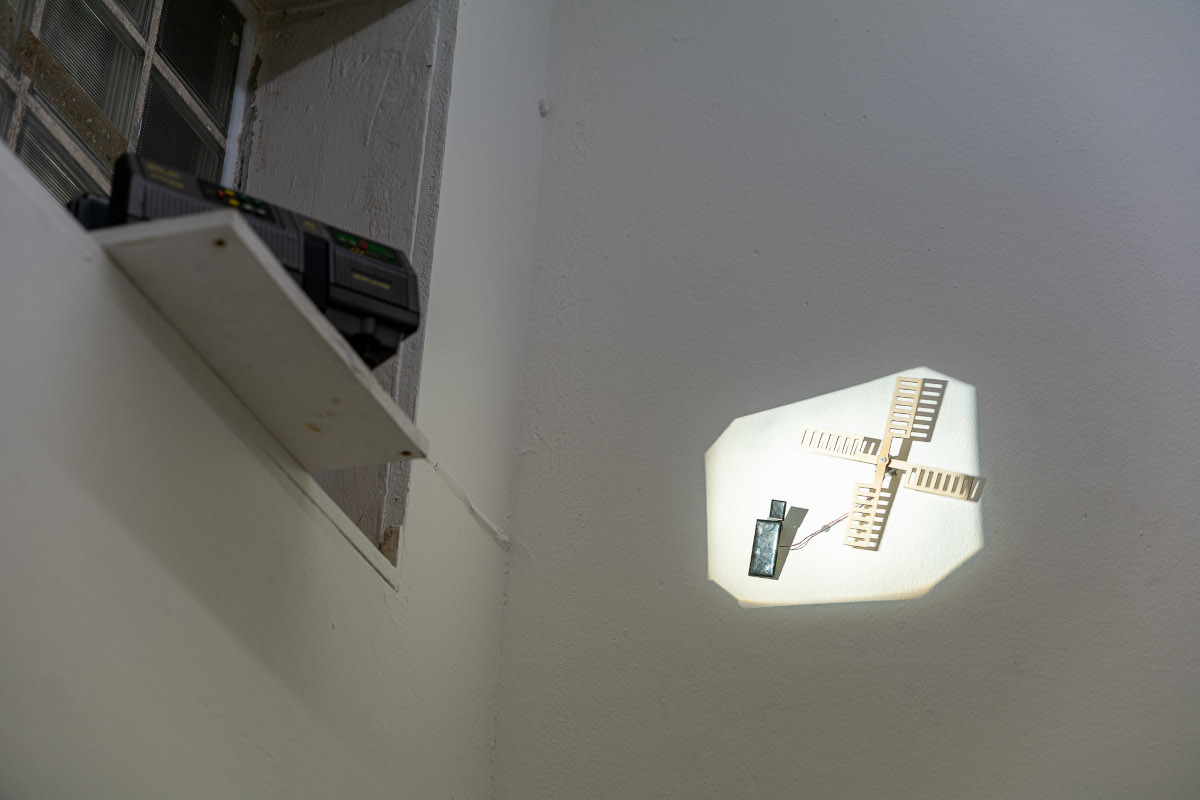 Ausstellungsansicht, Diaprojektor beleuchtet Solarzelle, die dann eine kleine Windühle antreibt