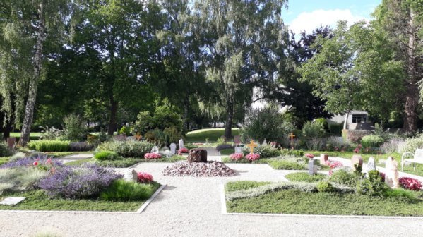 kreisförmige Wegeanlage mit Rasen und Blumen bepflanzten Urnengrabstellen