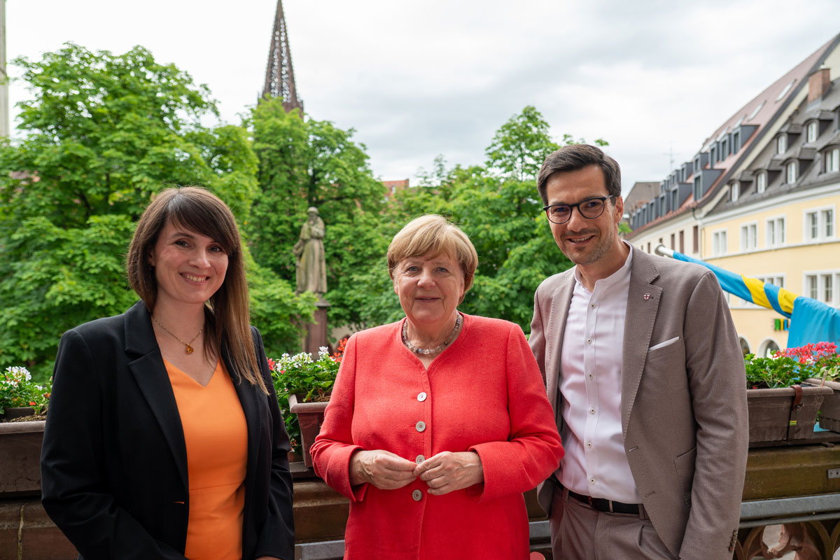 links Carolin Jenkner, mitte Angela Merkel, rechts OB Martin Horn; auf dem Rathausbalkon in der Innenstadt