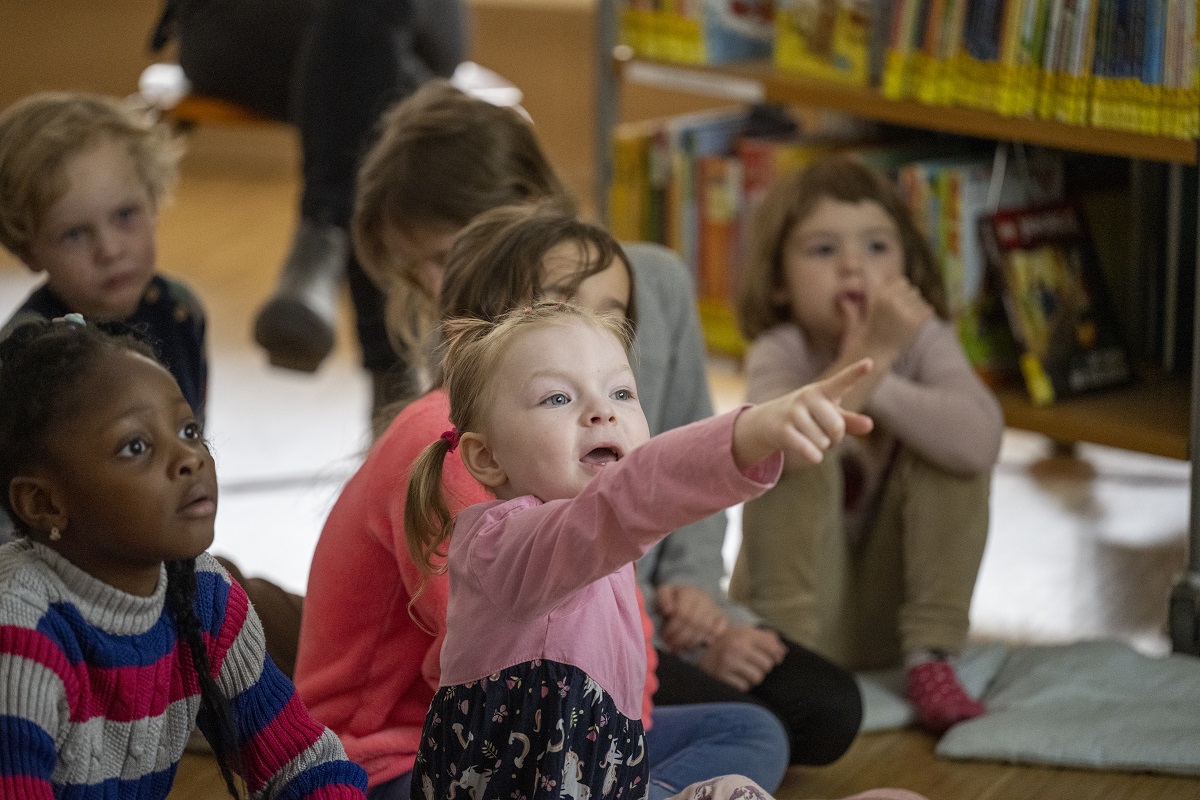 Kinder betrachten gespannt das Bilderbuchkino.
