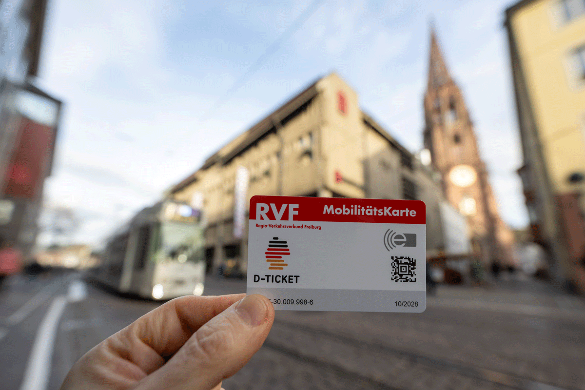 Im Vordergrund: Deutschlandticket, im Hintergrund: Freiburger Innenstadt