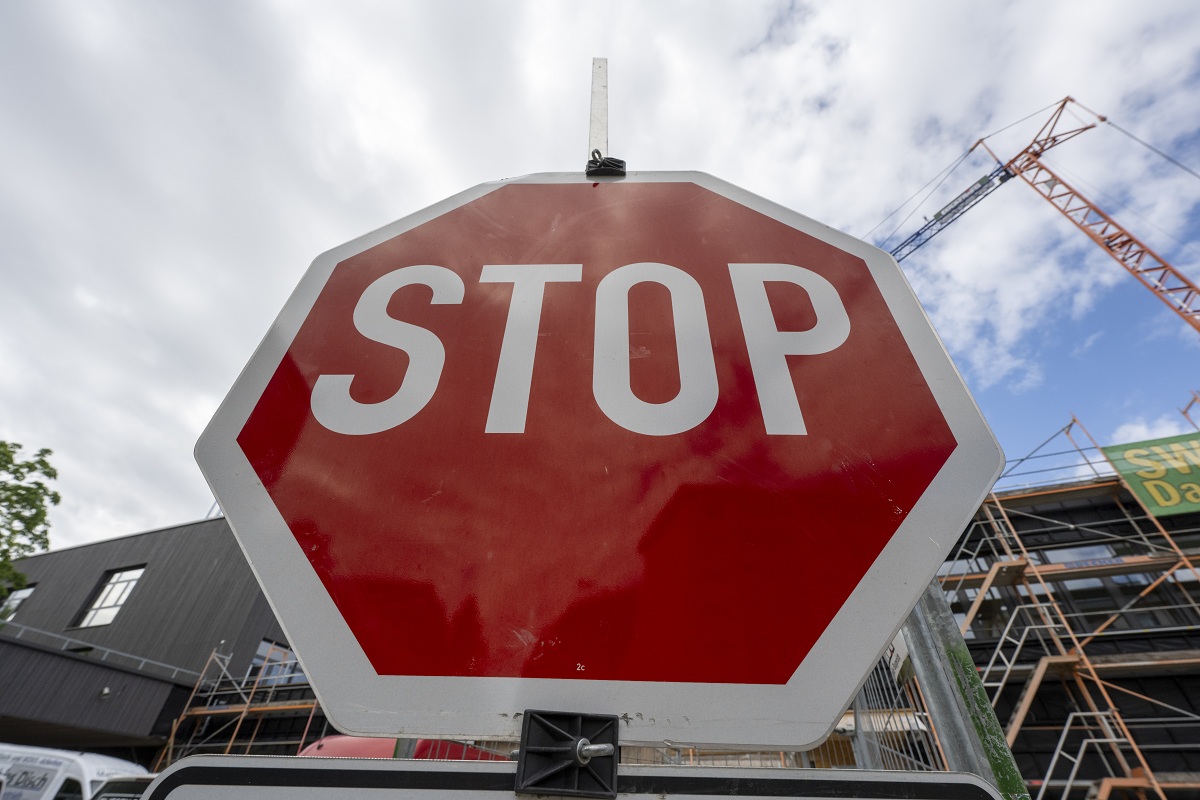 Ein großes rotes Stopschild vor einer Baustelle.