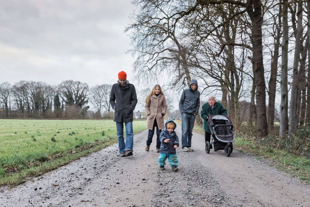 Menschen unterschiedlichen Alter spazieren auf einem Feldweg
