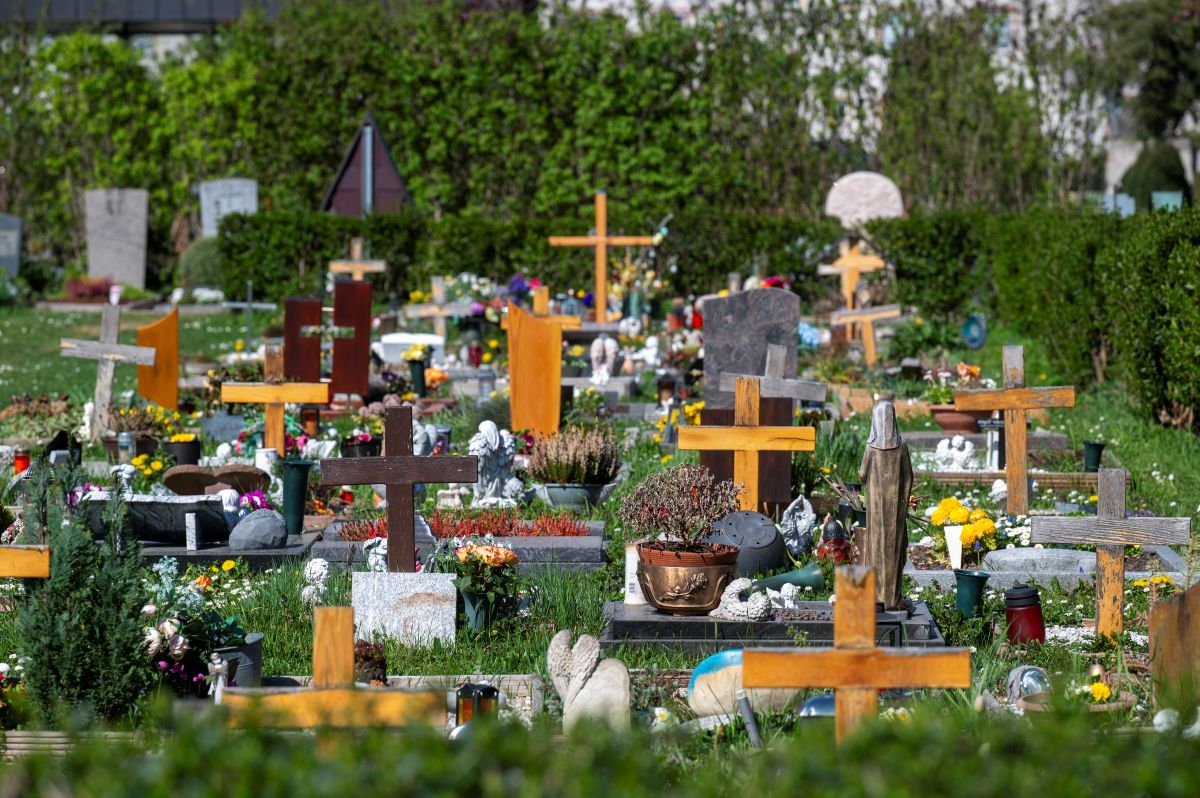 Grabsteine und Holzkreuze auf dem sonnigen Friedhof in Haslach