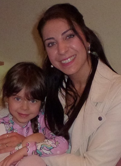 Ein Mädchen sitzt auf dem Schoß seiner Mutter.