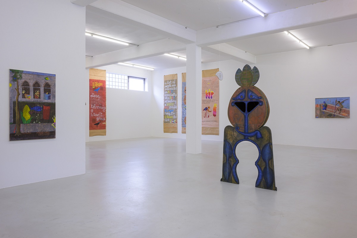 Ausstellungsansicht mit Skulptur, Eitempera-Malerei und bemalten Papierbahnen