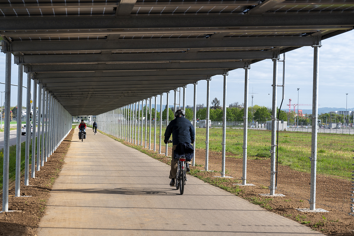 Fahrradfahrer auf Radweg, der mit Solaranlage überdacht ist