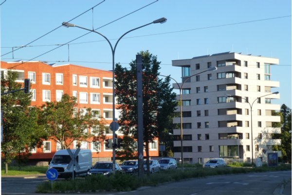 Gutleutmatten, Foto: Stadt Freiburg Zwei spurige Straße, dahinter Wohngebäude mit Bäumen und Wiese