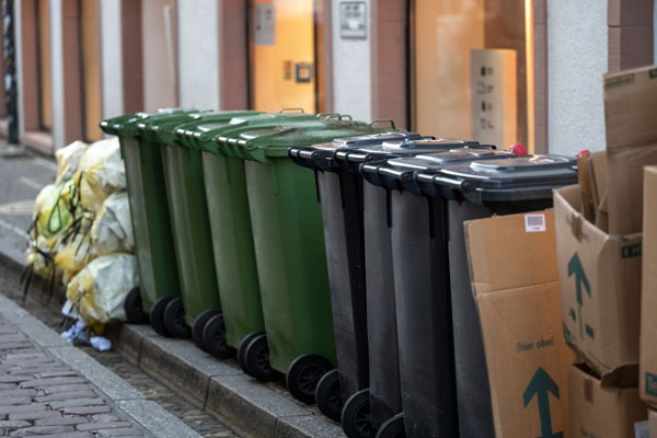 mehrere grüne und graue Mülltonnen in der Altstadt