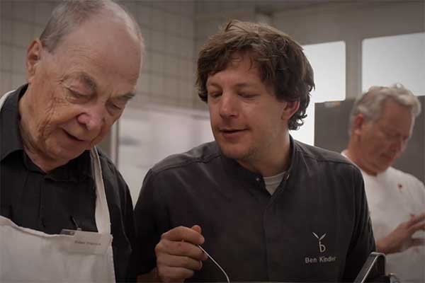 Koch Ben Kindler mit zwei anderen Männern in der Küche