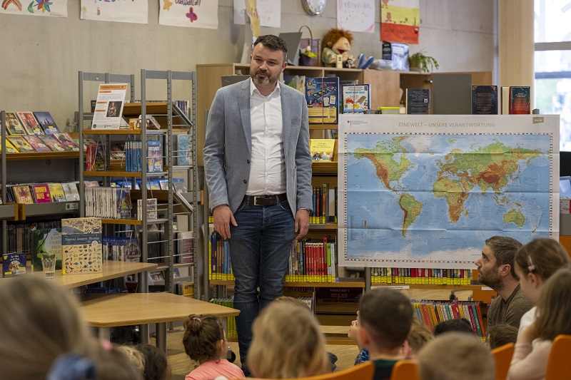 Johannes Merz (AKI) begrüßt die Kinder und Erwachsenen in der Mediothek.