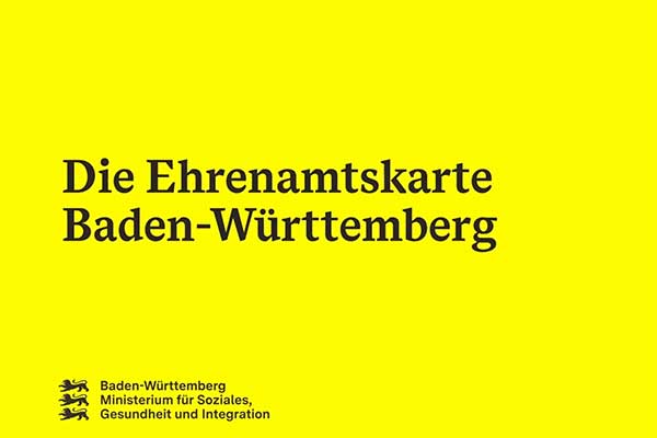 Gelber Hintergrund mit Text "Die Ehrenamtskarte Baden-Württemberg" mit Logo des Sozialministeriums