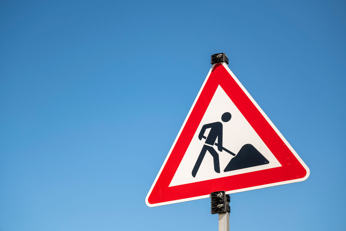 Baustellenschild vor blauem Himmel