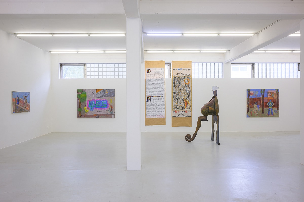 Ausstellungsansicht mit anziehbaren Skulpturen, Eitempera-Malerei und bemalten Packpapierbahnen