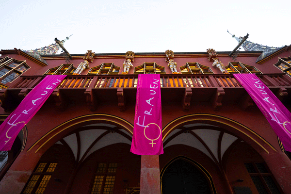 Historisches Kaufhaus Freiburg mit pinken Fahnen "Frauen"