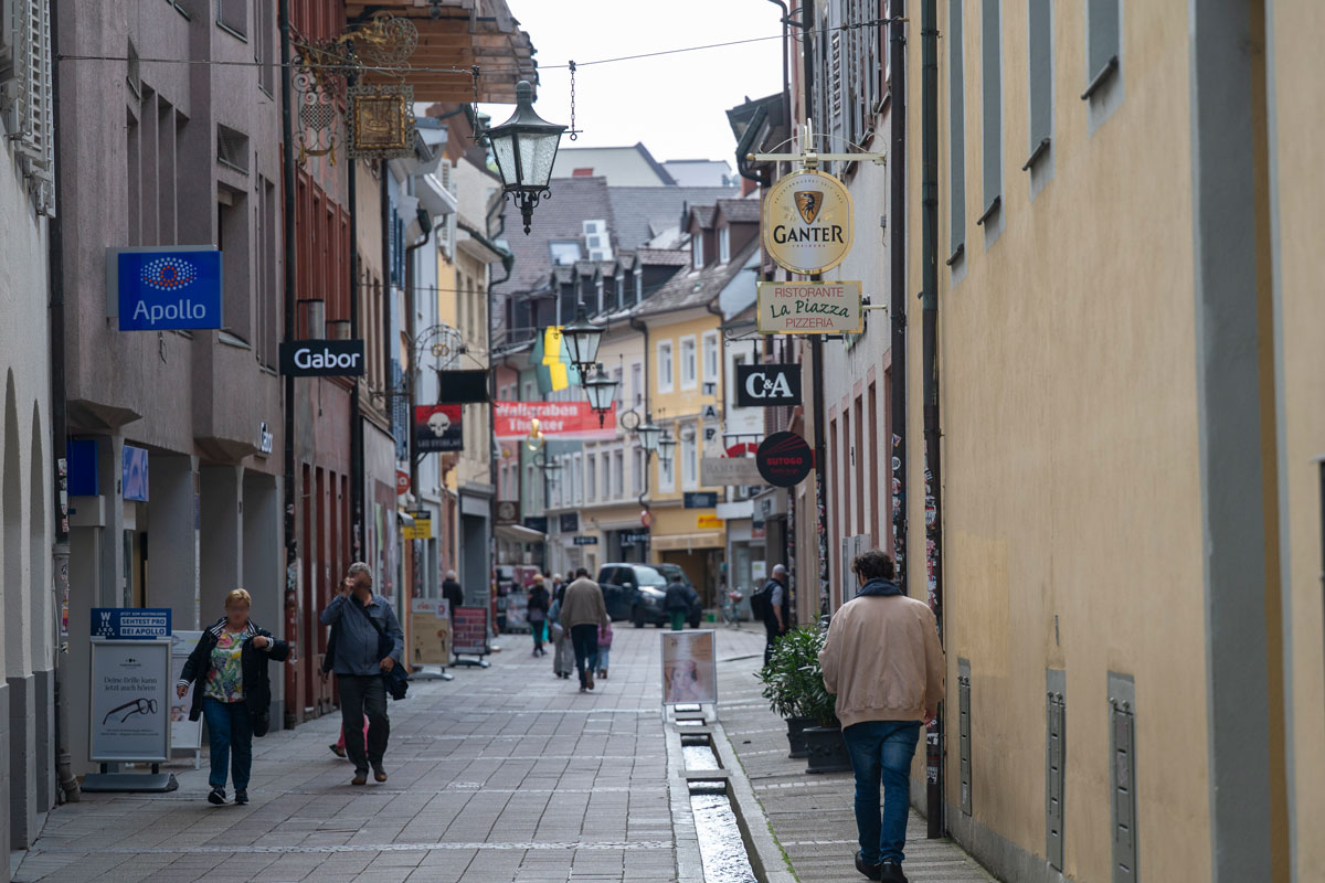 Rathausgasse in Freiburg, viele Läden und Menschen