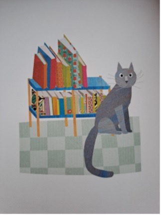 Eine Katze sitzt vor einem Bücherregal.