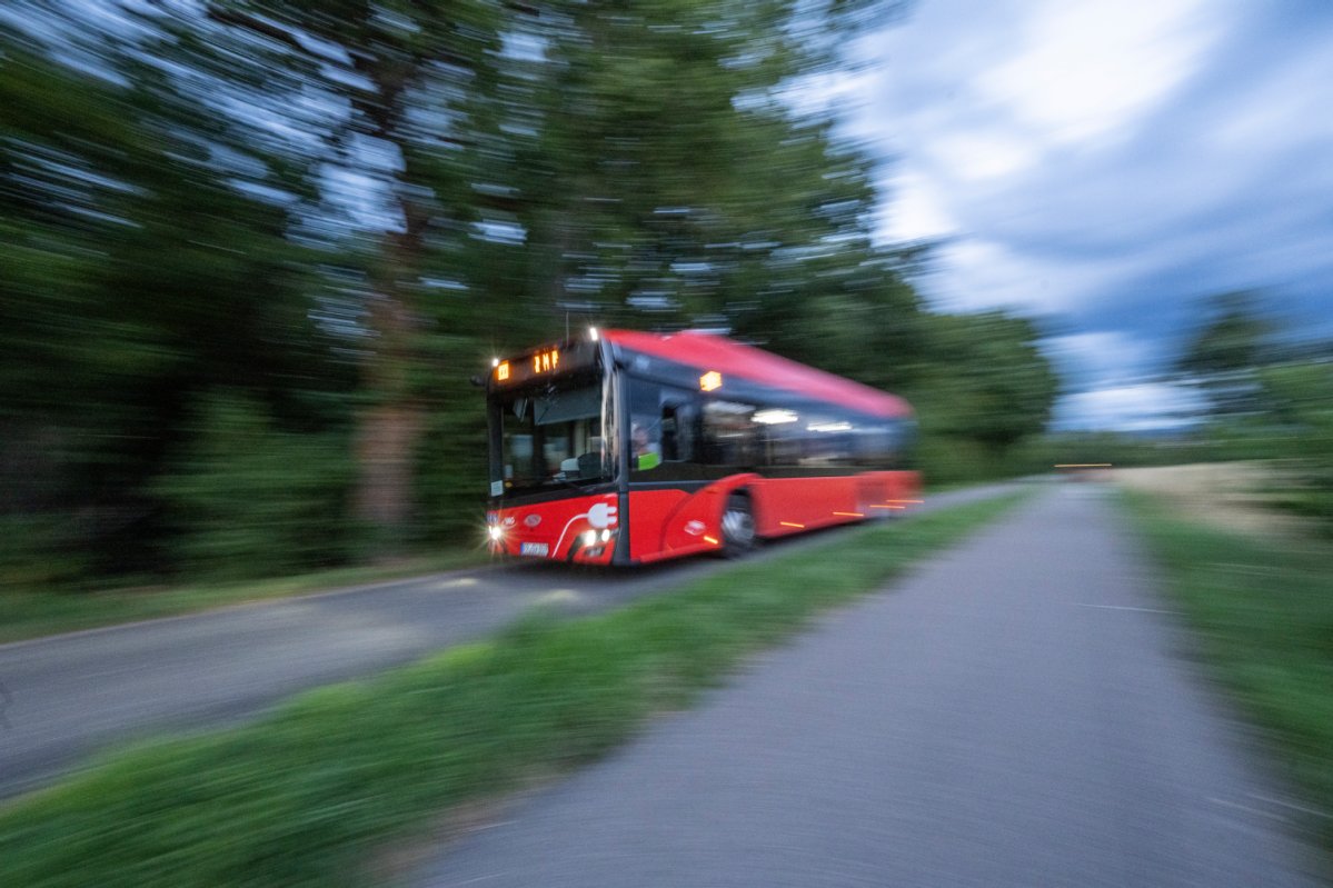Leicht verwaschenes Bild; roter Bus fährt zum ZMF-Gelände