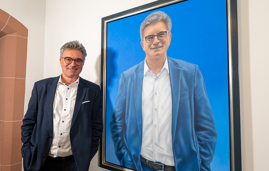 Ganz in Blau: Gemeinsam enthüllen der aktuelle Oberbürgermeister und sein Vorgänger ein Porträt von Dieter Salomon. Mit seinen kräftigen Farben setzt es einen auffälligen Akzent im Rathausflur.