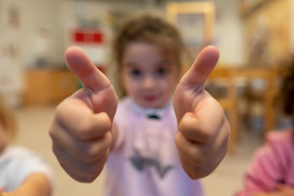 Ein Mädchen streckt zwei Daumen nach oben