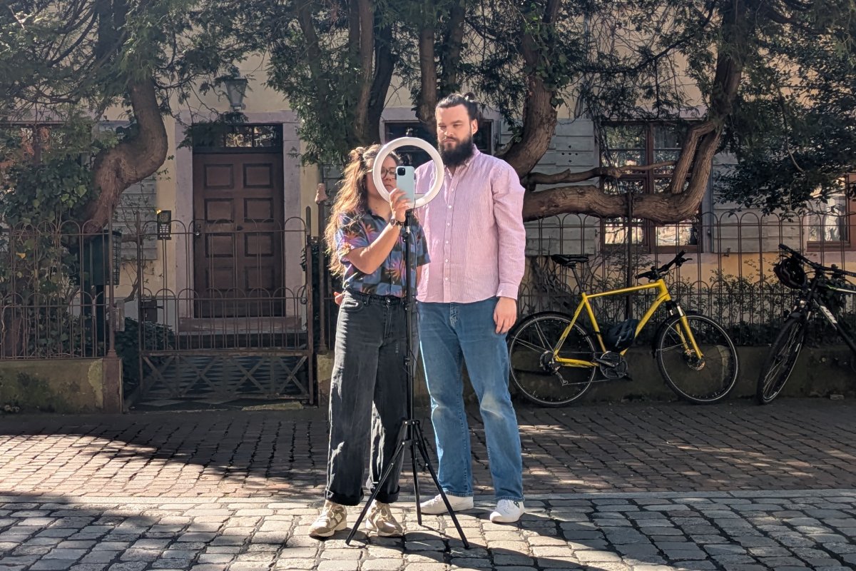 Zwei Personen bauen ein Stativ auf