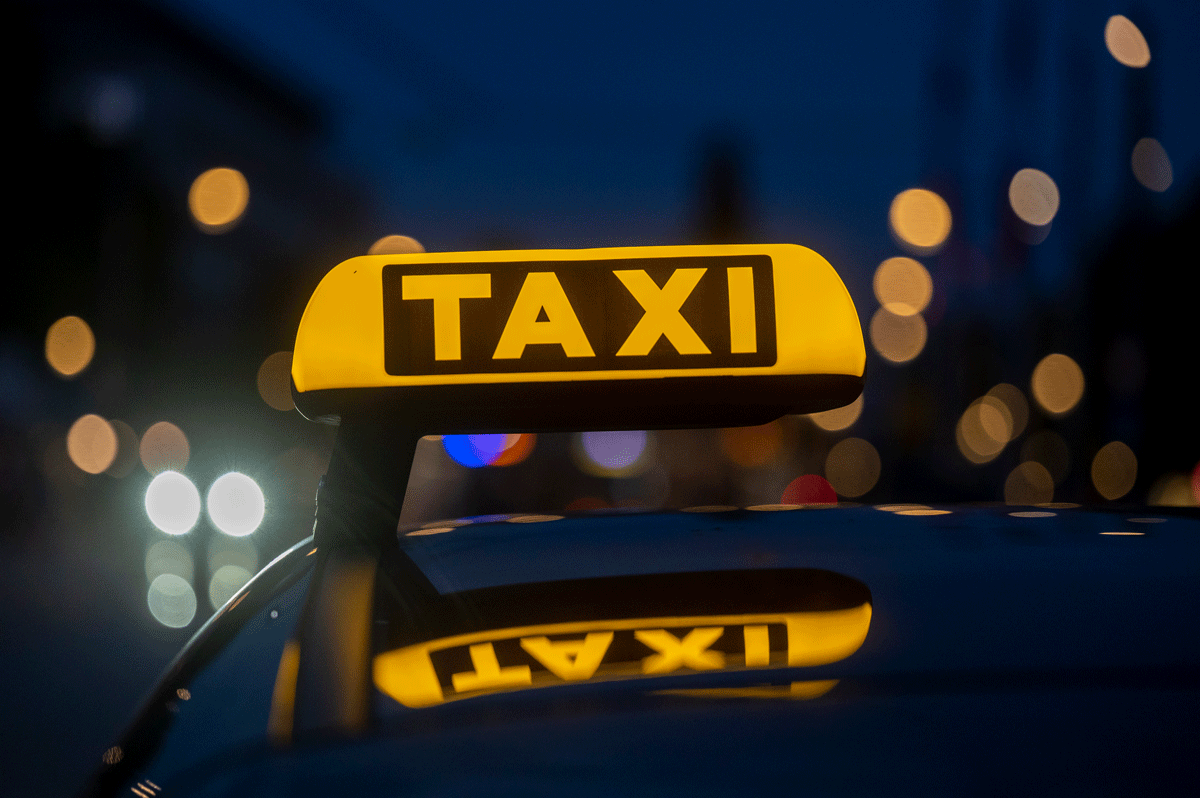 Taxischild auf Auto bei Nacht