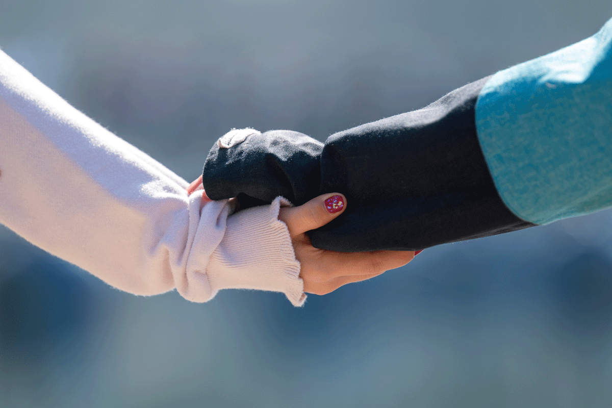 Zwei Personen halten sich an der Hand