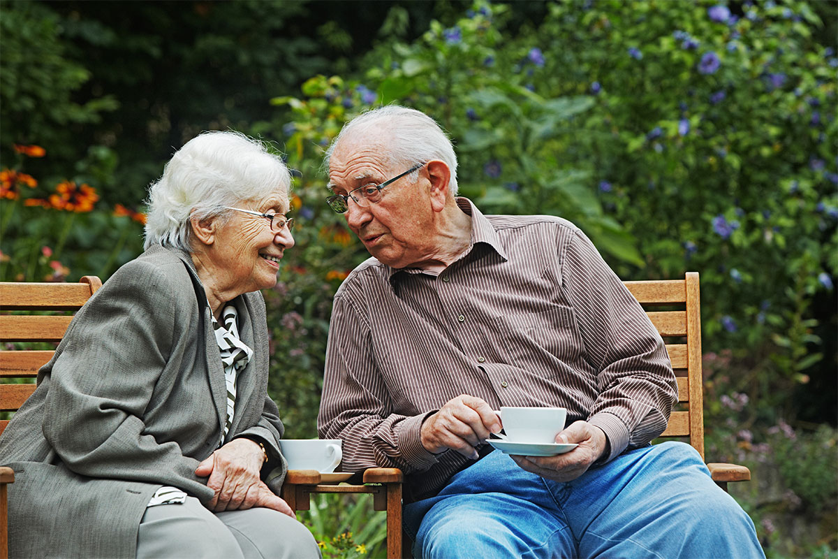 Seniorin und Senior trinken Kaffee im Garten