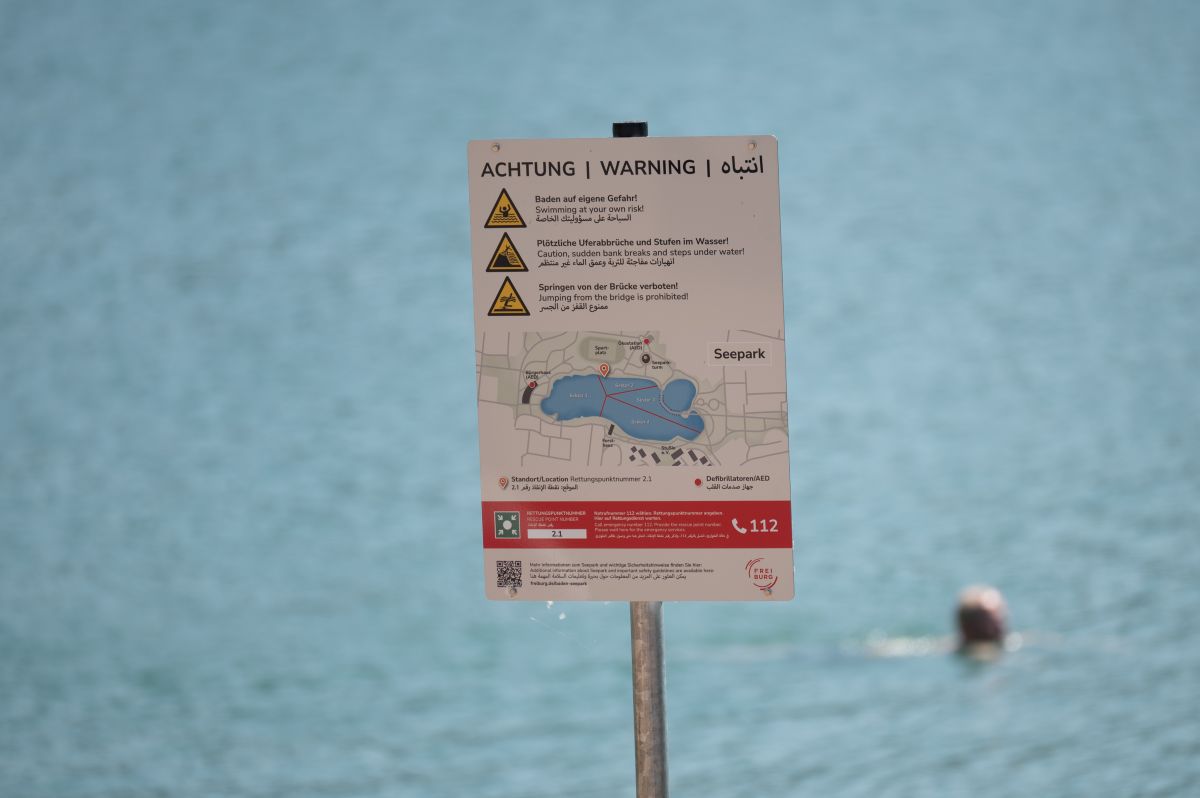 Ein Schild mit Sicherheitsregeln für Badende vor dem Flückiger See