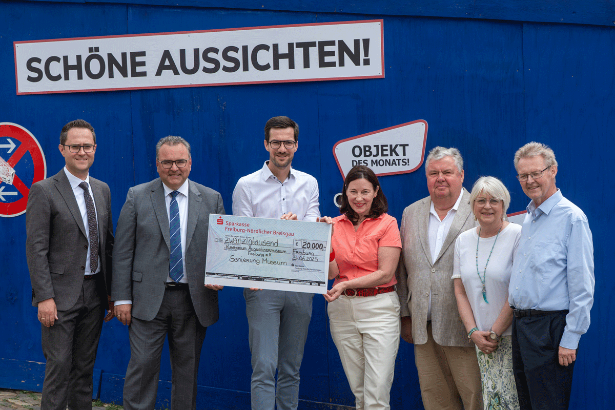 Mehrere Personen halten einen Scheck in der Hand
