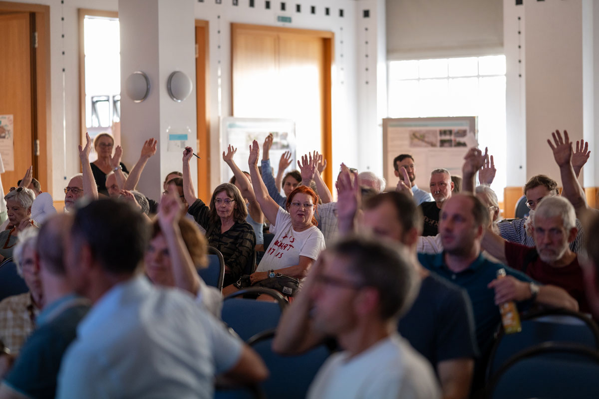 Workshop-Teilnehmer*innen im Plenum votieren per Handzeichen