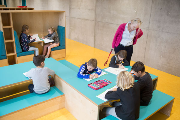 Schülerinnen und Schüler lernen an bunten Tischen und in Sitzecken. (Foto: A. J. Schmidt)