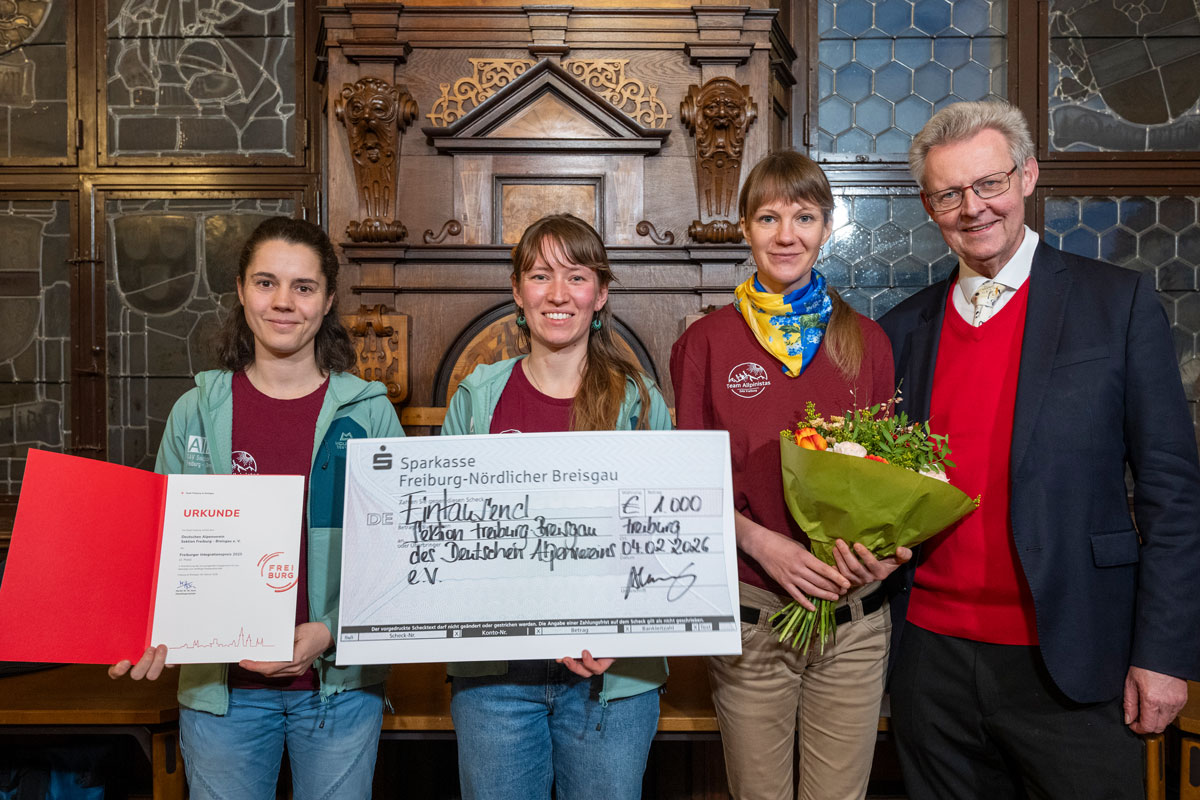 Vertreter*innen von Bike Bridge mit einem Spendencheck