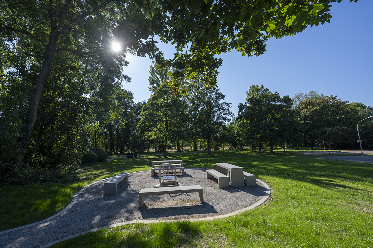 Bänke und Tische neben einer Grillstelle im Grünen