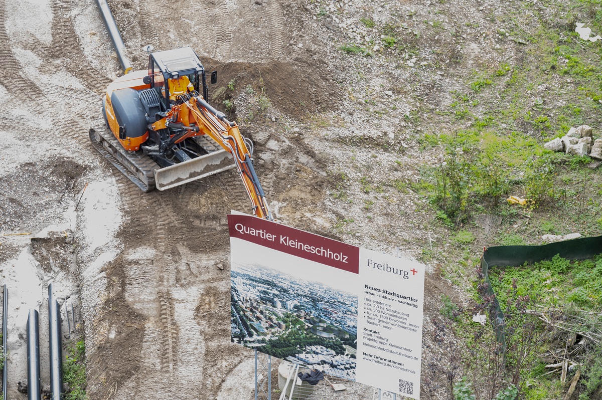 Die Baustelle Kleineschholz mit einem Infoschild und einem Bagger.
