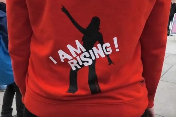 Foto: Frauenhorizonte e.V. Person trägt roten Pulli mit Aufschrift "I am Rising"