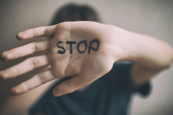 Person mit Schirftzug auf der Hand: "Stop"