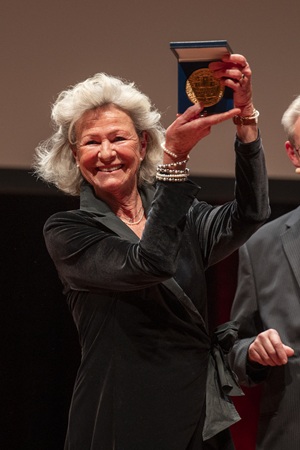 Annette Theobald hält lächelnd das Goldene Stadtsiegel in die Höhe.