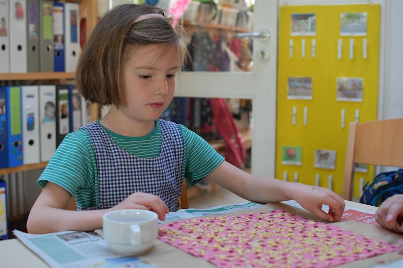 Ein Kind bastelt ein Wachstuch.