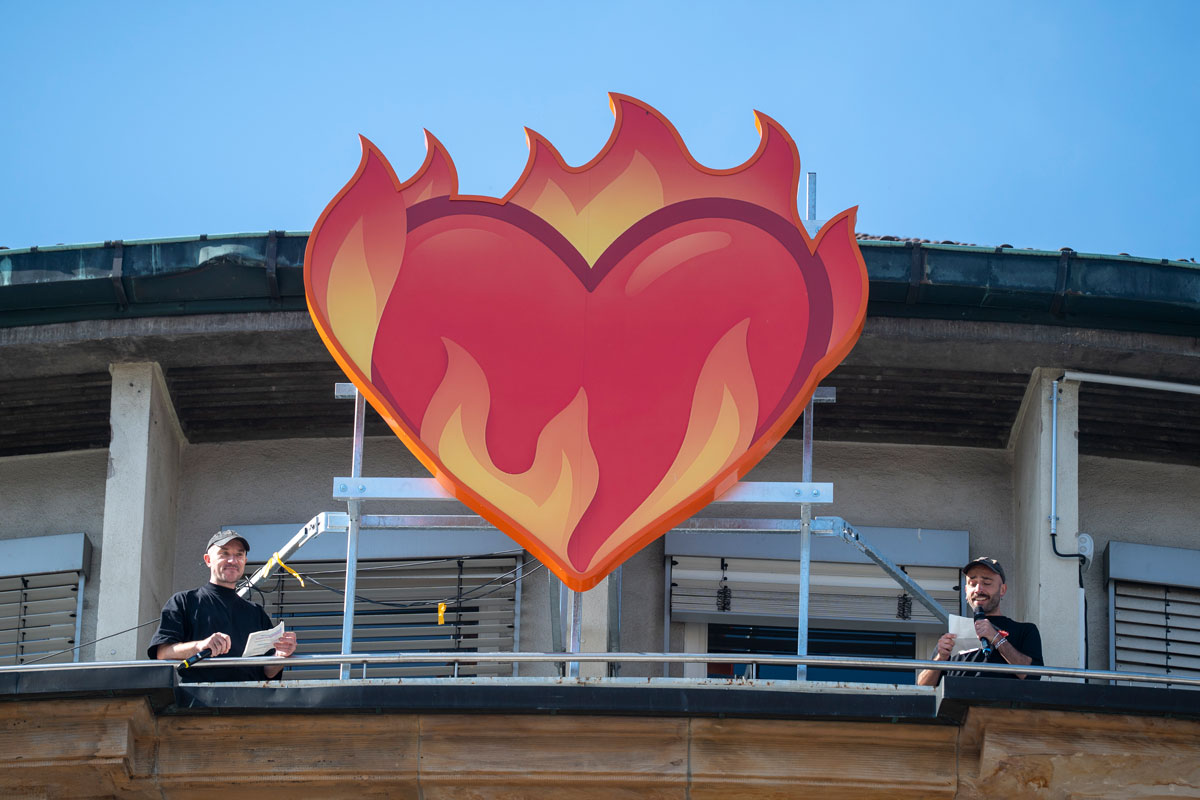 Rotes Herz in Flammen - Emoticon, auf dem Dach des Stadttheaters