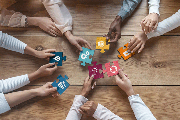Diverse Menschen halten gemeinsam Puzzle