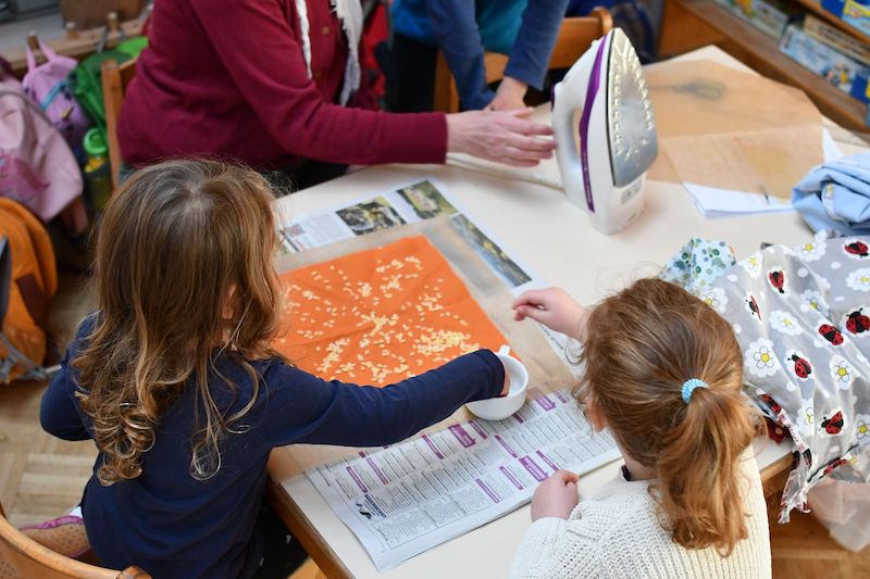 Kinder basteln Wachstücher.