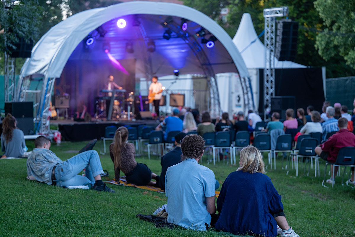Open-Air-Konzert mit Bühne und Zuschauer*innen