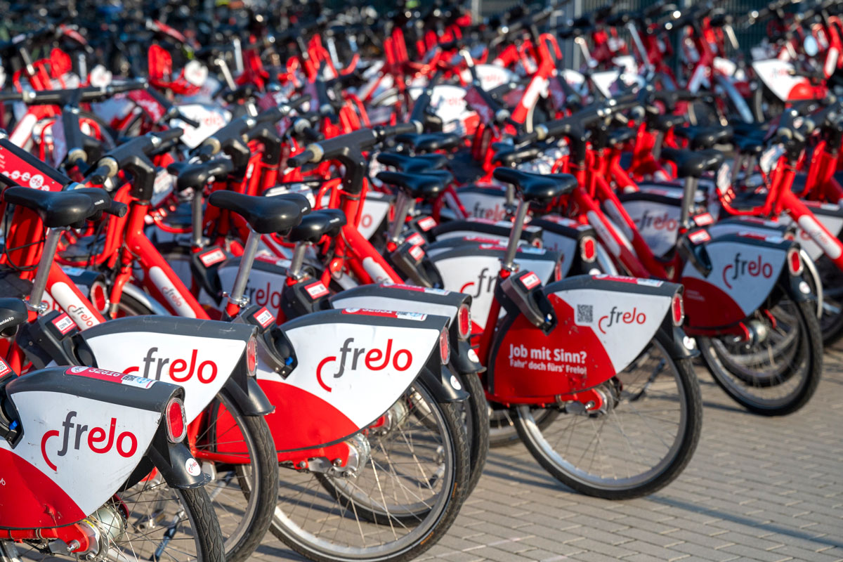 Viele abgestellte rot-weiße Frelo Leihfahrräder