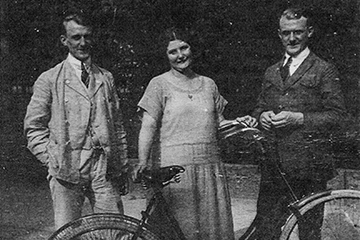 Drei Personen stehen hinter einem Fahrrad