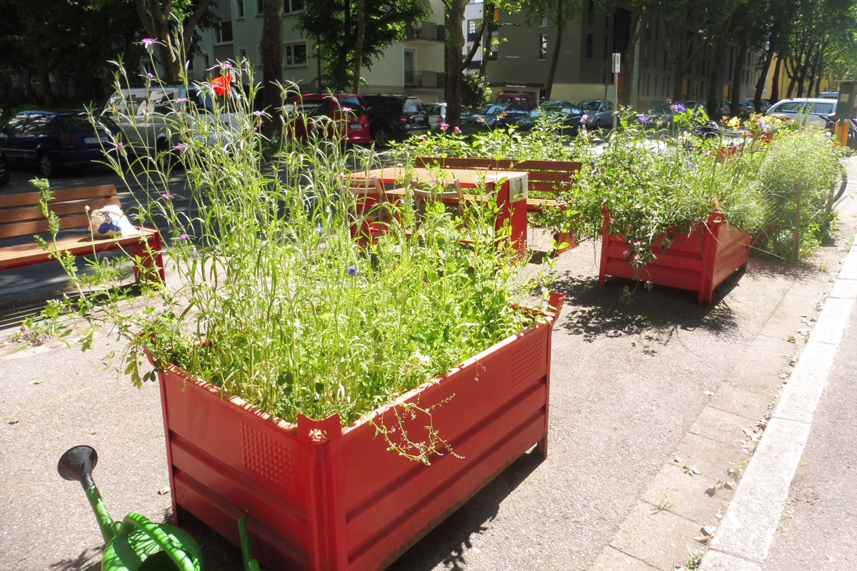 Rote Hochbeete im Straßenraum