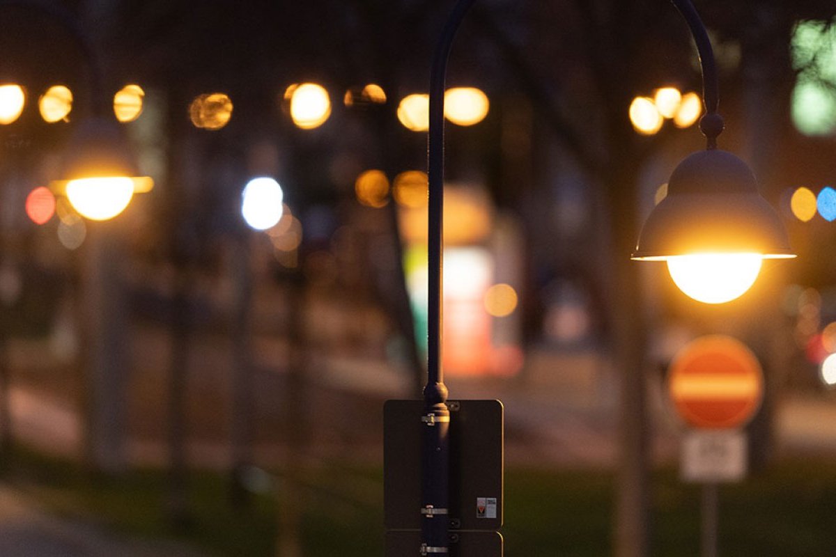 Angeschaltete Straßenlaternen in einer Reihe bei Nacht