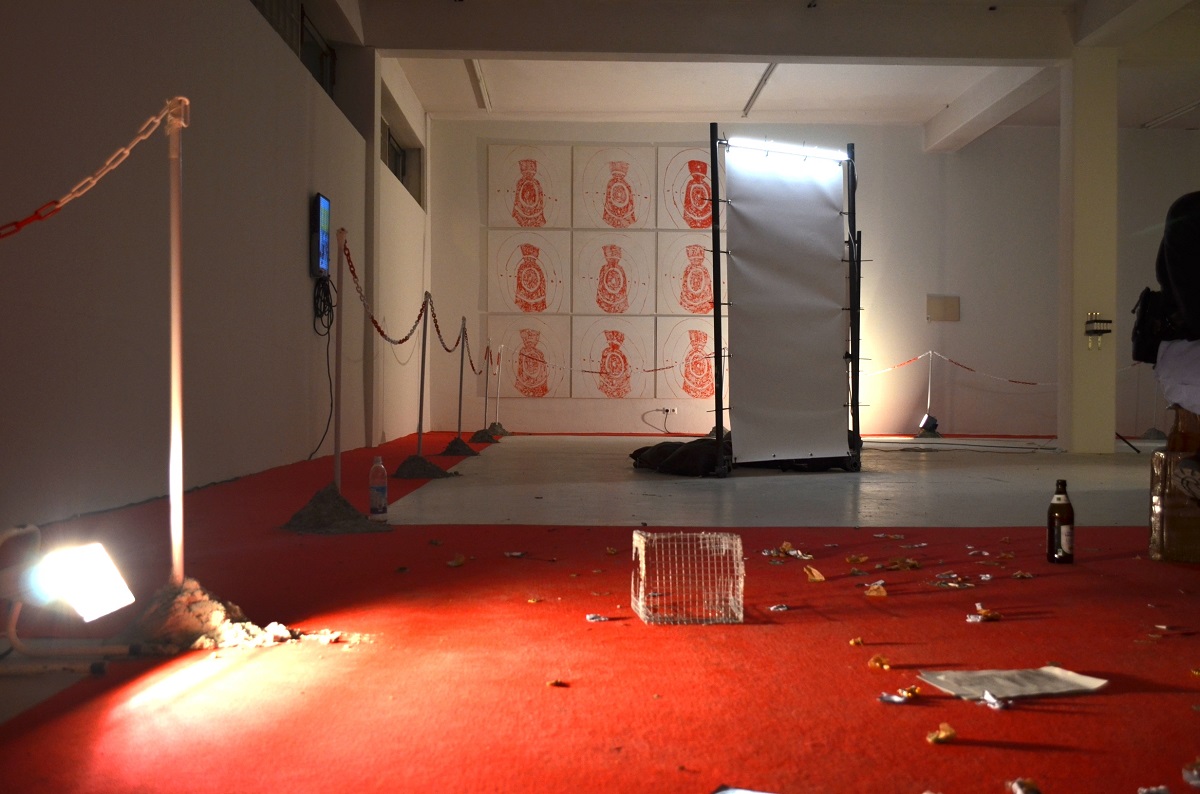 Ausstellungsansicht nach Eröffnung, roter Teppich mit einbetonierten Absperrungen, Kaugummis, Kaugummipapiere und andere Reste der Eröffnung auf rotem Teppich liegend