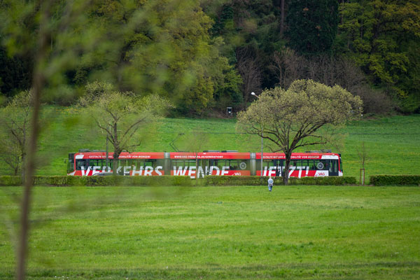 Eine rote Straßenbahn mitten im Grünen