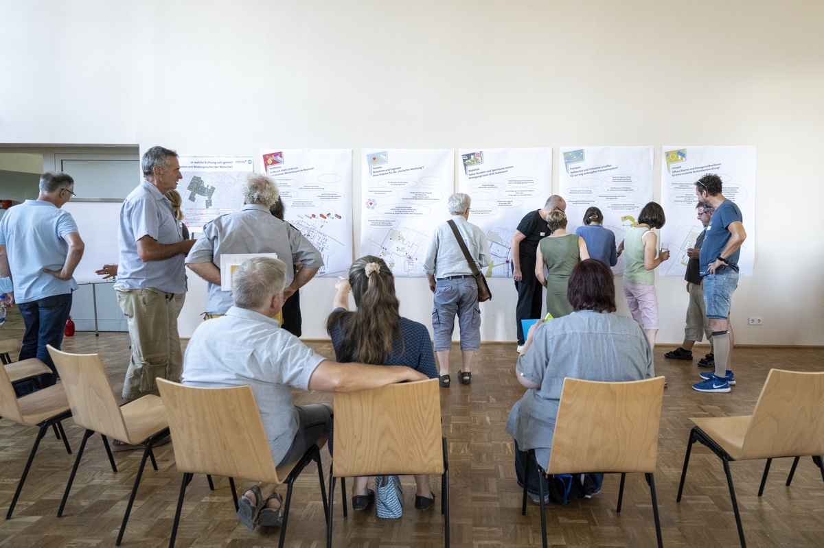 Menschen vor einer Wand mit Postern